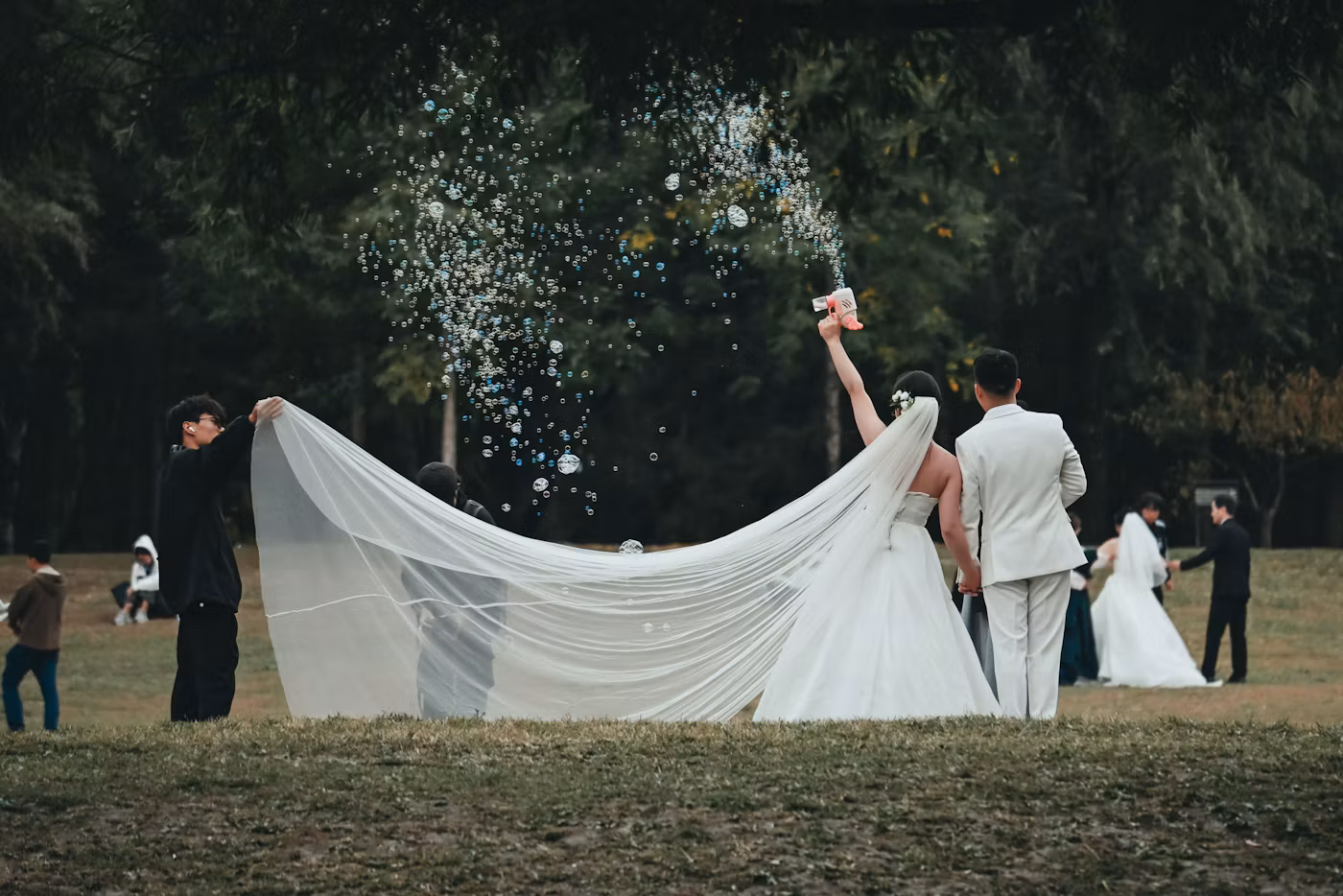 Newlyweds beneath a veil outdoors
